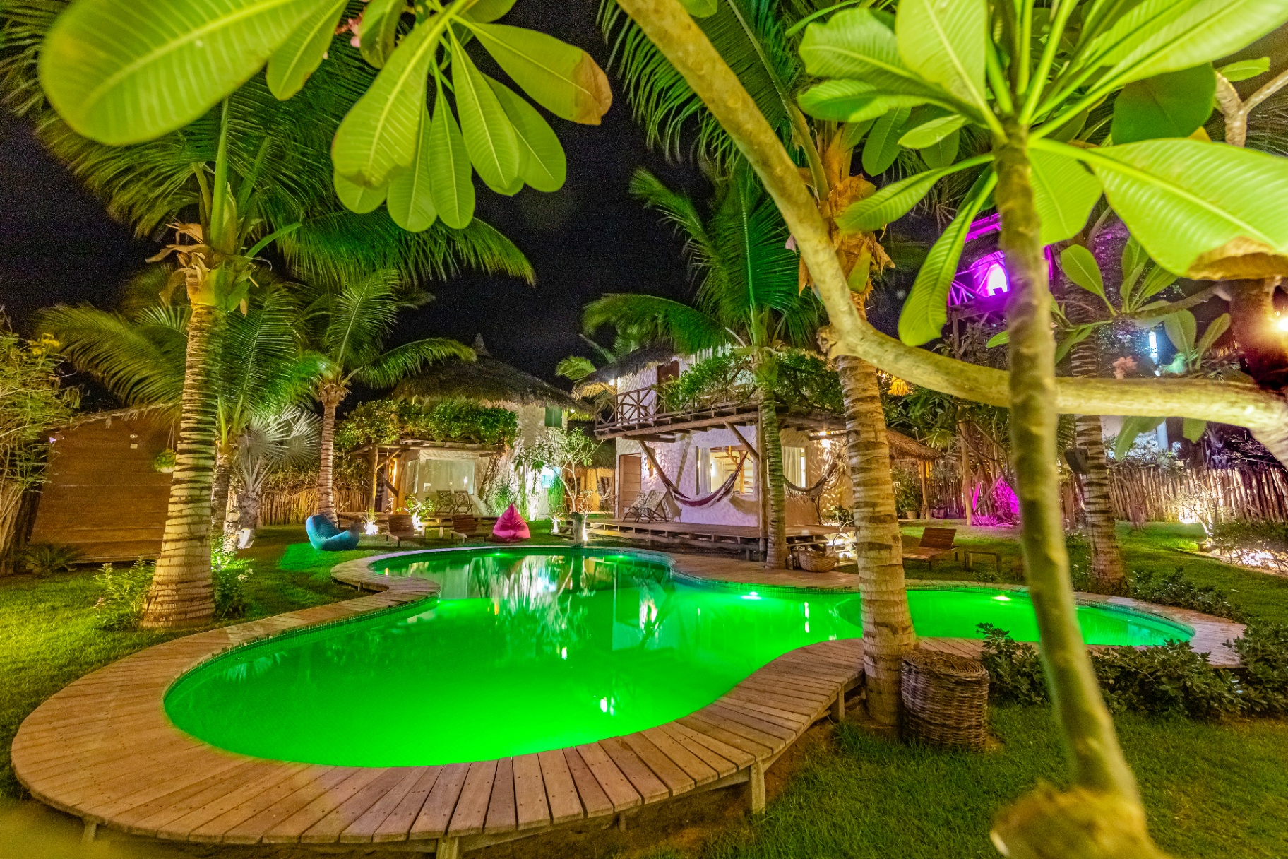 Piscina Kai à noite entre coqueiros